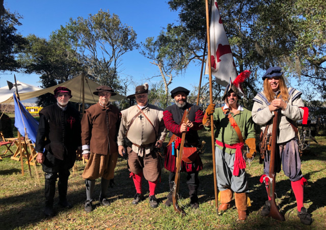 Six men standing outdoors in 16th century Spanish and French colonial costume