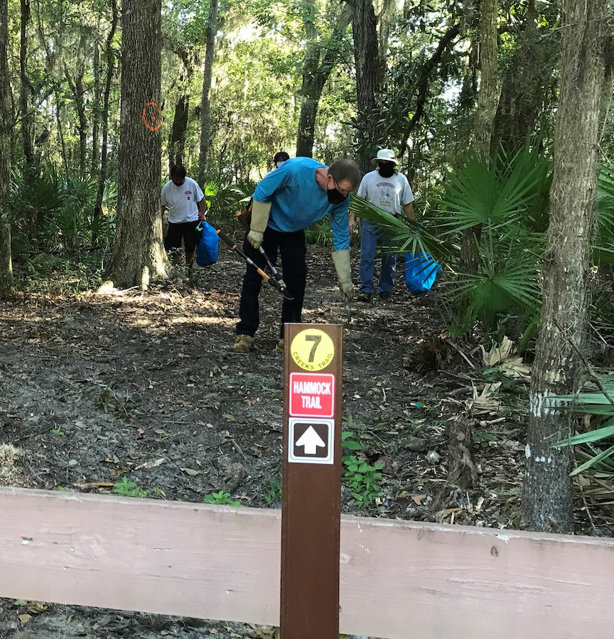 Trail marker with volunteers in background