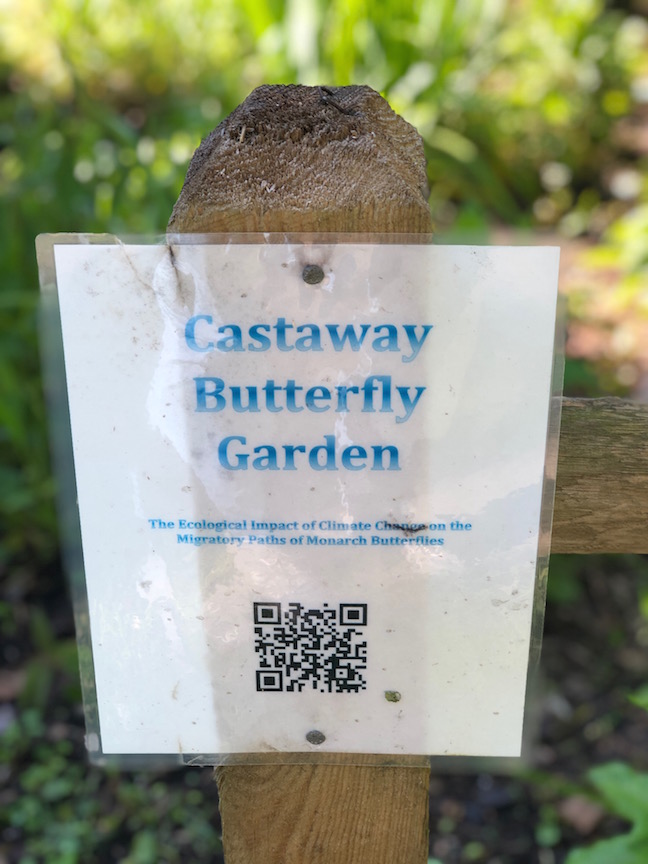 Wooden post with laminated butterfly garden sign