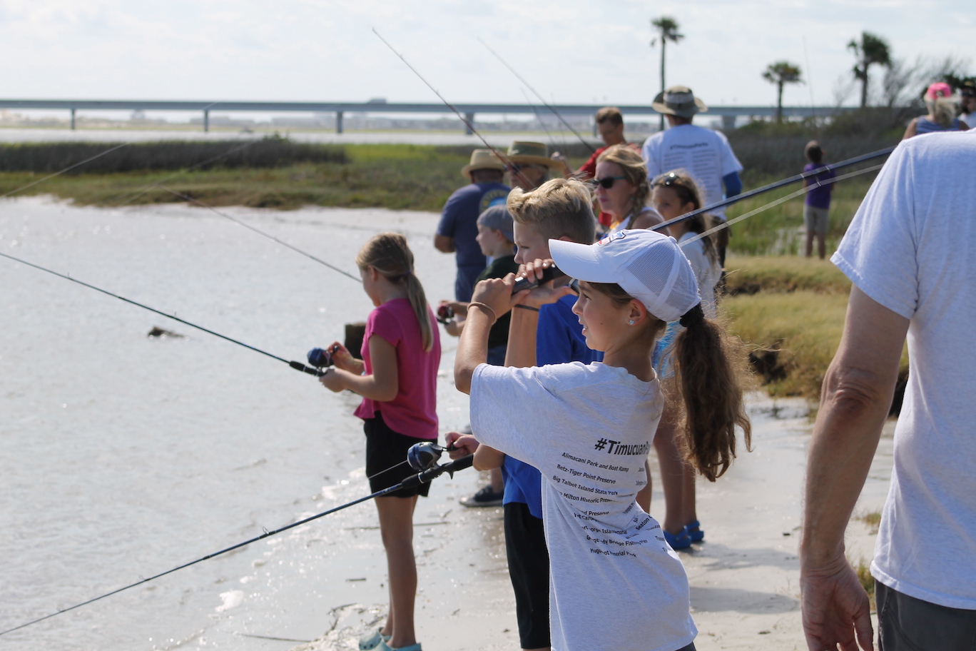 Group of children fishing from shoreline